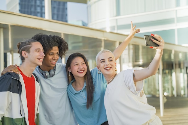 Amigos adolescentes multiétnicos tomando una foto de grupo selfie y riendo felices en el campus Tecnología