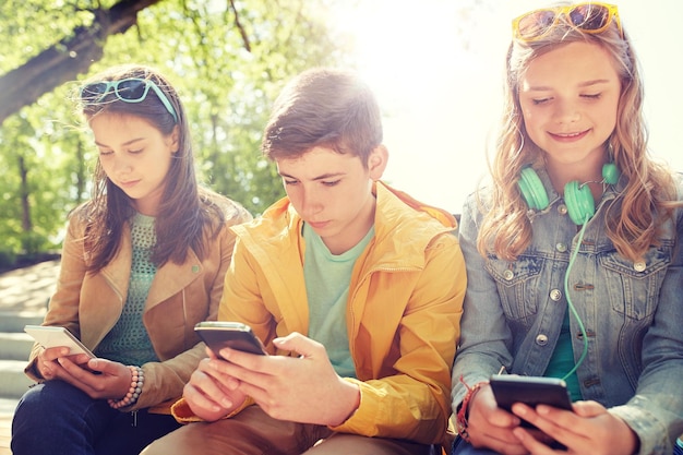 Foto amigos adolescentes con teléfonos inteligentes y auriculares