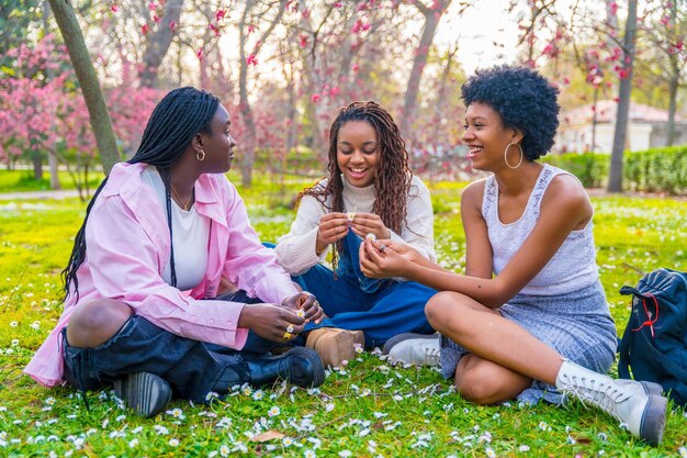 Amigos africanos charlando sentados en un parque en primavera