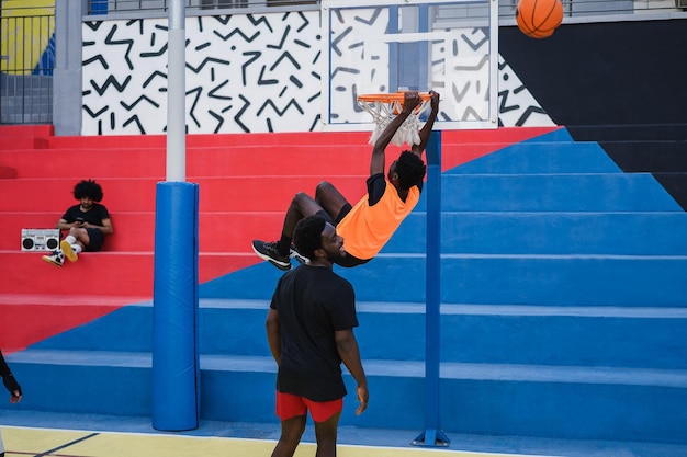 Amigos africanos jogando basquete ao ar livre Concentre-se nas mãos dos caras penduradas no anel