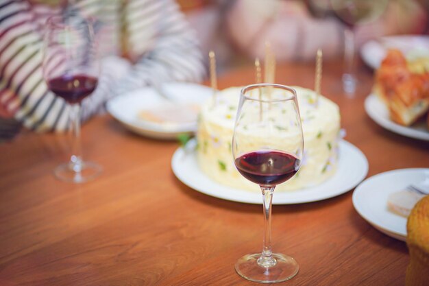 Amigos alegres a desfrutar de casa Festa de Aniversário Irmã asiática a animar a beber vinho vermelho a celebrar com bolo de aniversário