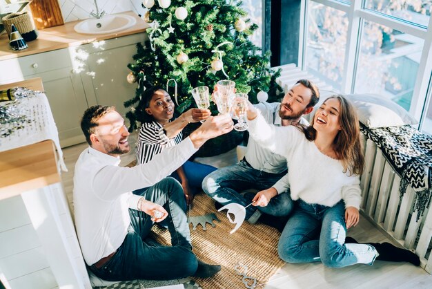 Amigos alegres brindando celebrando la Navidad