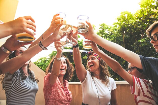 Foto amigos alegres brindando com bebidas enquanto estão ao ar livre