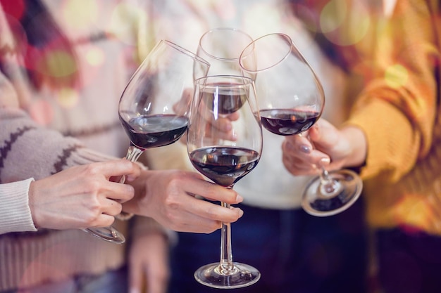 Amigos alegres disfrutando de la fiesta de cumpleaños en casa Amigos asiáticos animando bebiendo vino tinto celebrando la fiesta de Navidad o Año Nuevo