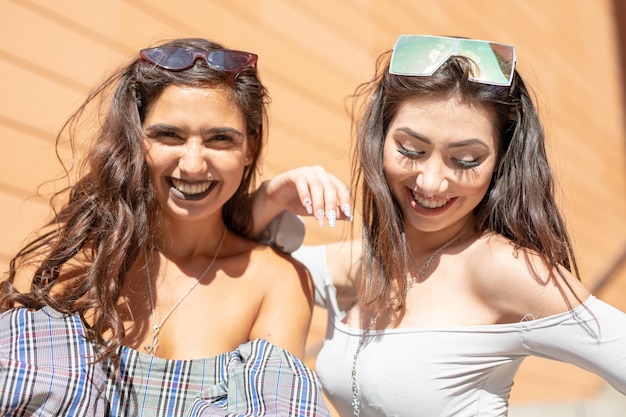 Amigos alegres e à moda na cidade durante o dia ensolarado