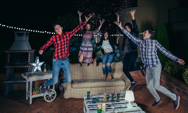 Amigos alegres haciendo fiesta en el patio durante la noche