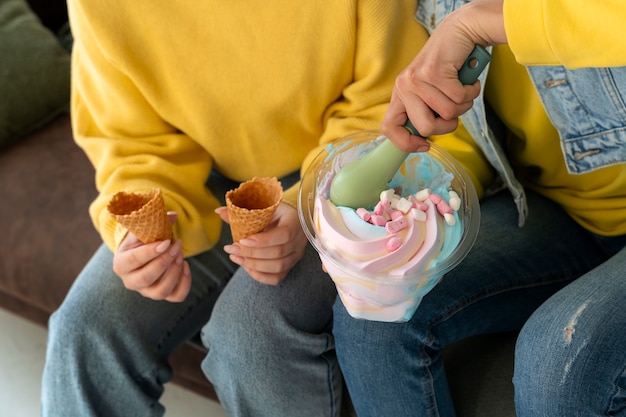 Amigos de alto ángulo comiendo sabroso helado