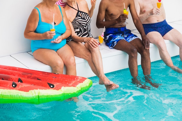 Amigos ancianos en la fiesta de la piscina durante el verano