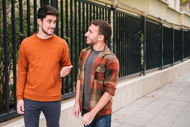 Amigos, andar, falando, em, rua