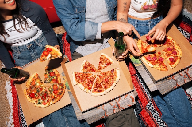 Foto amigos de ángulo alto comiendo pizza