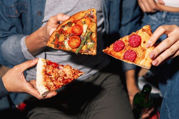 Amigos de ángulo alto comiendo pizza