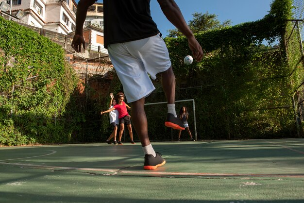 Amigos de ángulo bajo jugando al fútbol