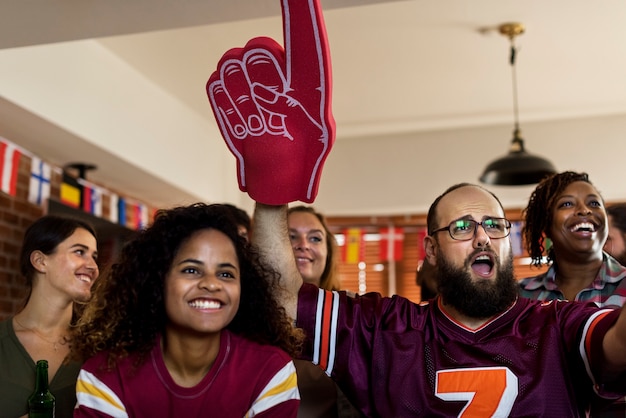 Amigos animando deporte en el bar juntos