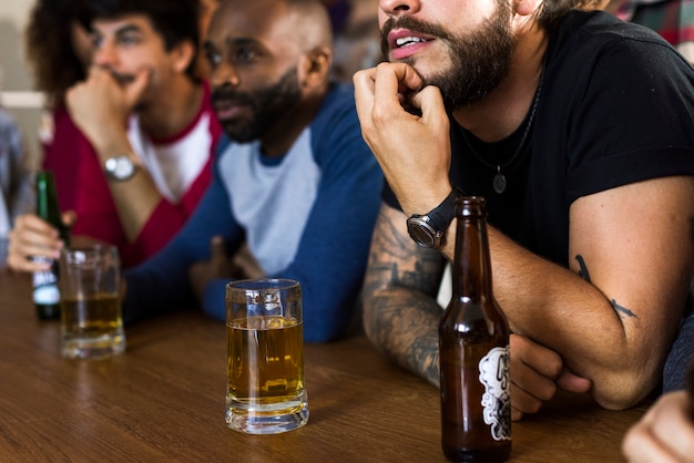 Amigos animando el deporte en el bar juntos