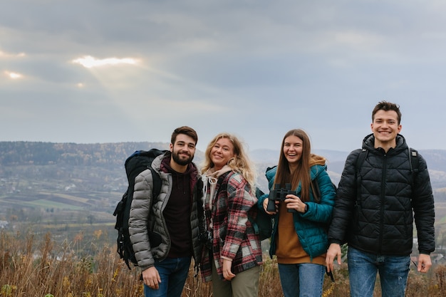 Amigos aproveitam os raios do sol brilhando através das nuvens nas montanhas