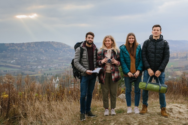 Amigos aproveitam os raios do sol brilhando através das nuvens nas montanhas