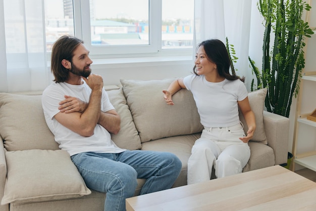 Amigos asiáticos masculinos e femininos sentados no sofá e se divertindo conversando entre si com um sorriso se divertindo juntos Estilo de vida em felicidade em casa
