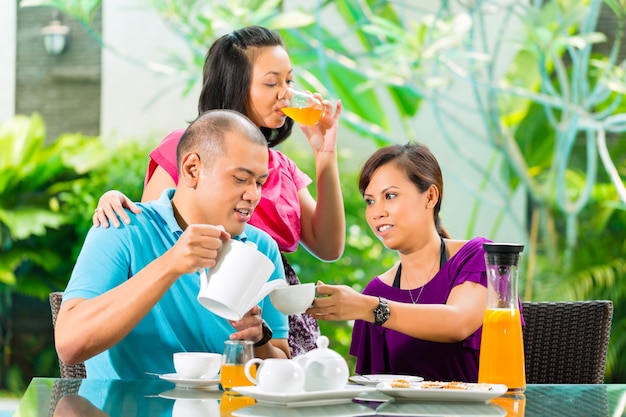 Amigos asiáticos tomando café na varanda de casa