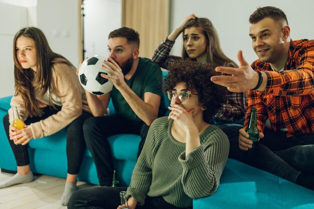 Foto amigos assistindo jogo de futebol em casa e torcendo