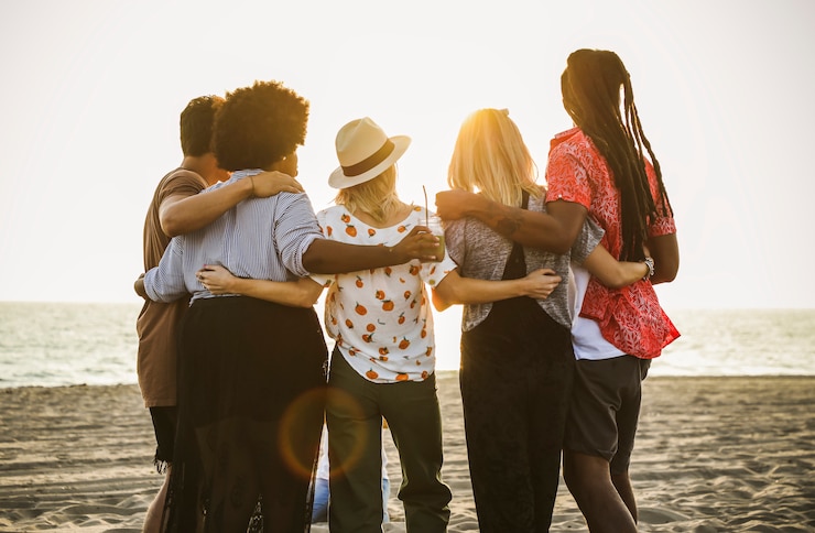Foto amigos assistindo o pôr do sol na praia