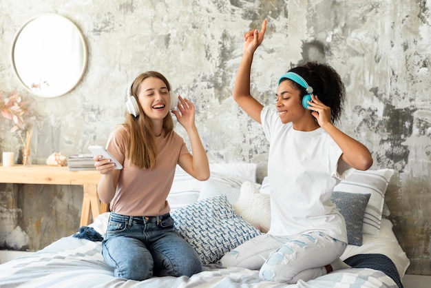 Amigos bailando en la cama en casa