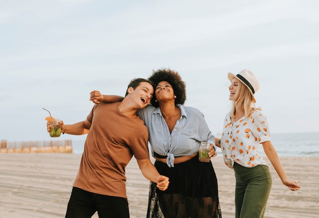 Foto amigos bailando y divirtiéndose en la playa.