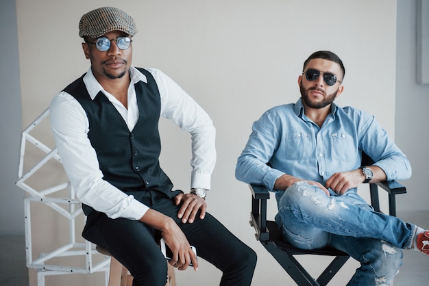 amigos barbudos posando con gafas de sol en la silla