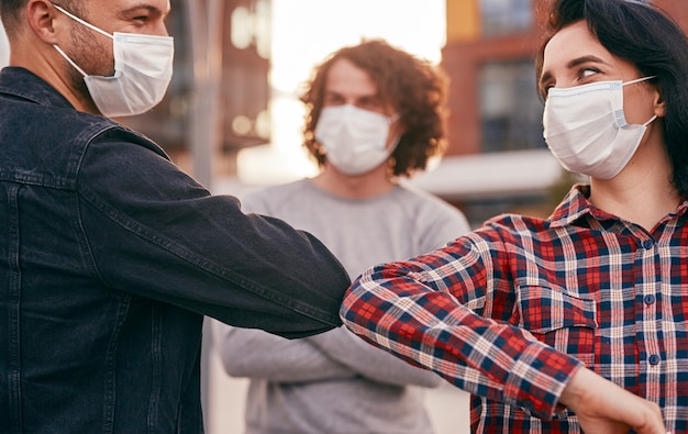 Foto amigos batendo cotovelos durante a epidemia