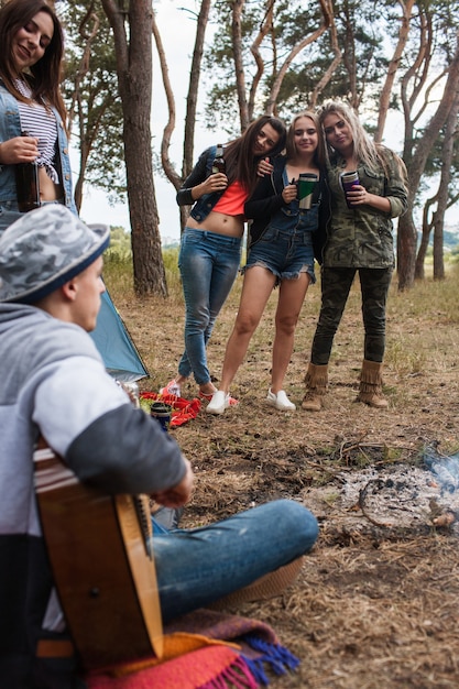 Foto amigos beben resto guitarra concepto de turismo de naturaleza. estilo de vida de camping.