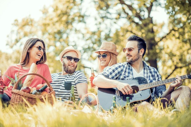 Amigos bebendo cerveja e ouvindo música no parque