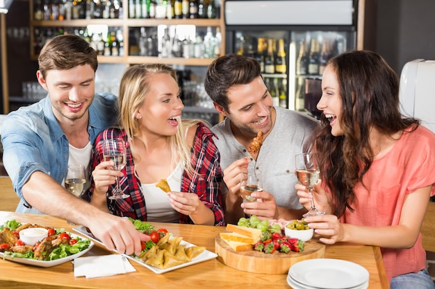 Amigos, bebendo vinho branco e comendo