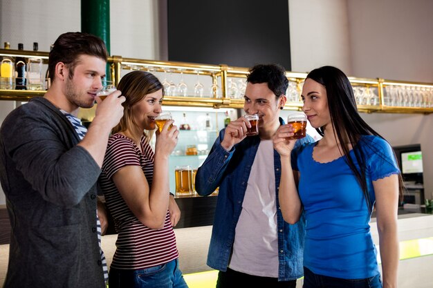 Foto amigos bebiendo cerveza en barra de bar