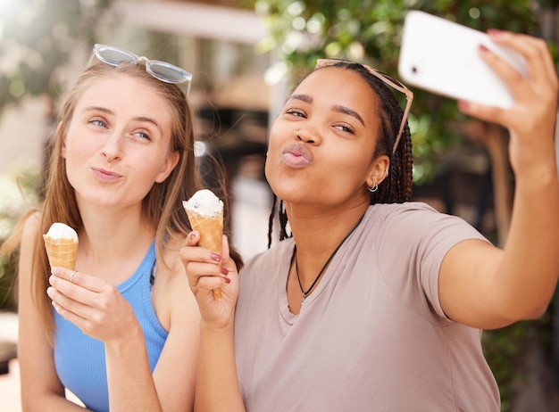 Amigos con beso de helado y selfie al aire libre con viajes felices con postre y pasar tiempo juntos en vacaciones Publicación en redes sociales cara de puchero en foto y mujer joven comiendo helado en Italia