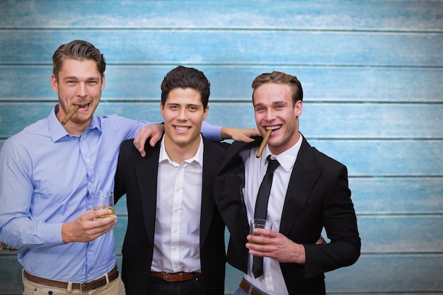 Amigos bonitos tomando uma bebida juntos contra pranchas de madeira