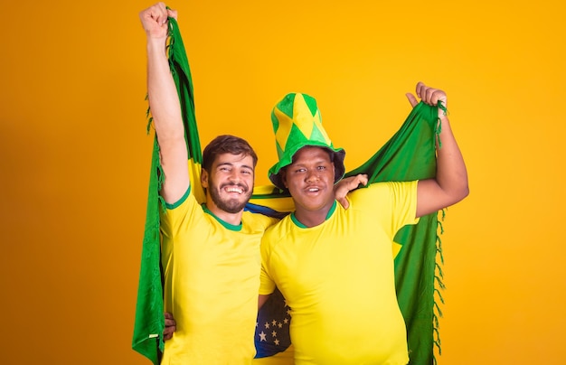 Amigos brasileiros diversidade latino-americana torcendo pela copa do mundo brasil 2022 segurando a bandeira do brasil futebol torcendo e vibrando gritando gol alegre e felizxA