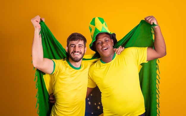 Amigos brasileiros diversidade latino-americana torcendo pela copa do mundo brasil 2022 segurando a bandeira do brasil futebol torcendo e vibrando gritando gol alegre e felizxA