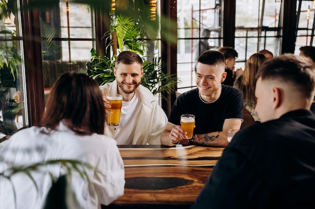 Amigos brindando e se divertindo juntos bebendo cerveja e coquetéis na happy hour em um restaurante de pub estilo de vida social conceito de festa de tempo