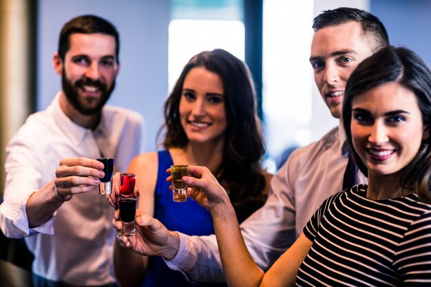 Amigos brindando con tragos de alcohol en un bar