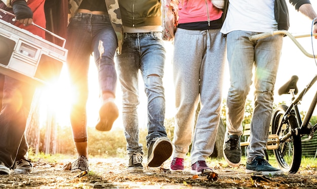 Amigos caminando en el parque de la ciudad con halo de luz de fondo y sunflare