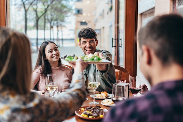 Amigos en una celebración dentro de un bar comiendo y bebiendo