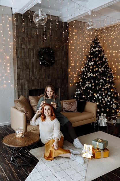 amigos celebram o Natal em casa no fundo de uma linda árvore de Natal