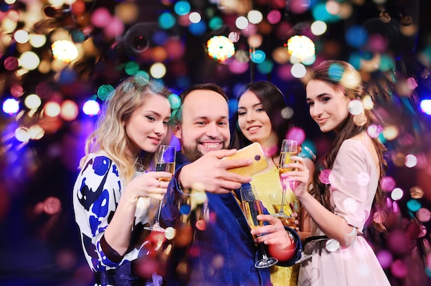 Los amigos celebran el evento, ríen, bailan y beben champán.