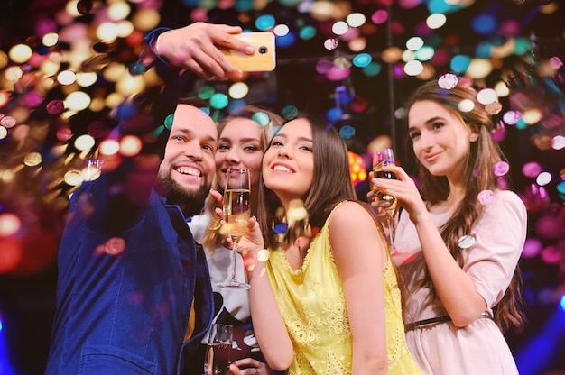 Foto los amigos celebran el evento, ríen, bailan y beben champán.