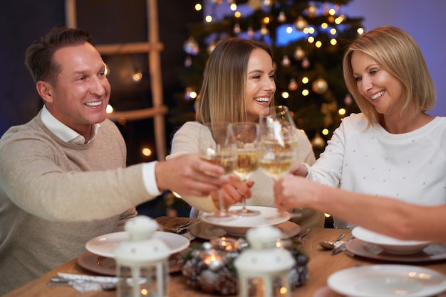 Amigos celebrando a festa de Natal com vinho. Foto de alta qualidade