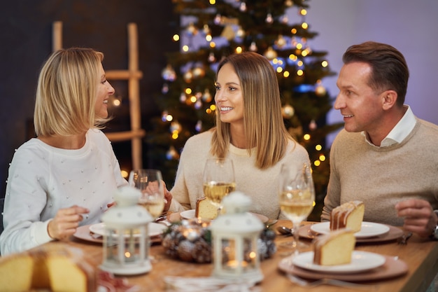 Amigos celebrando a festa de Natal com vinho. Foto de alta qualidade