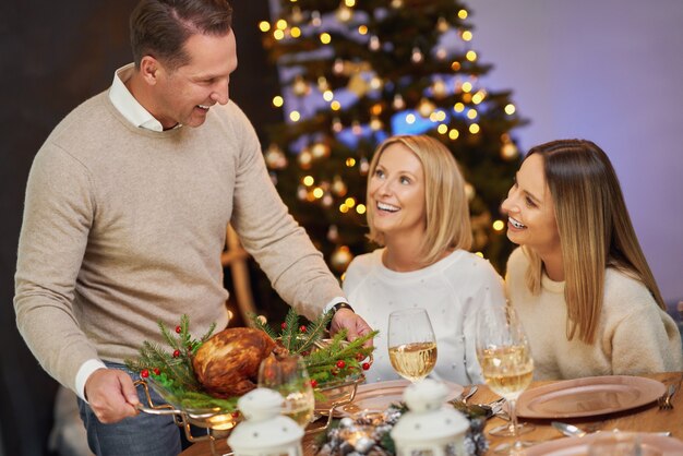 Amigos celebrando a festa de Natal com vinho. Foto de alta qualidade