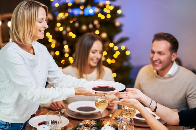 Amigos celebrando a festa de Natal com vinho. Foto de alta qualidade