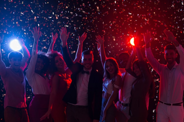 Foto amigos celebrando el año nuevo en el club nocturno, bailando y divirtiéndose juntos, espacio de copia