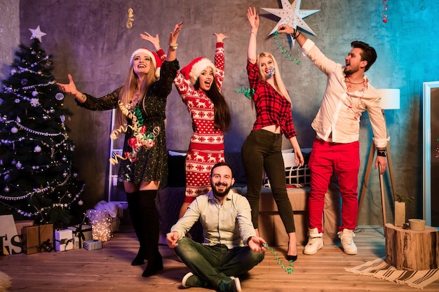 Amigos celebrando la Navidad o la víspera de año nuevo en casa