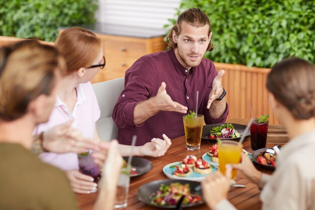 Amigos charlando durante el almuerzo en la cafetería